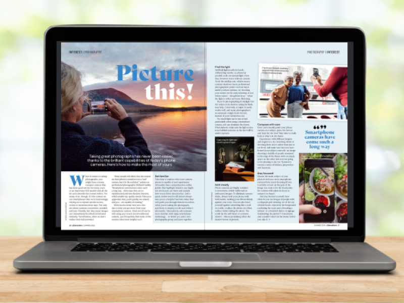 a laptop has a double page spread of a magazine open on the screen