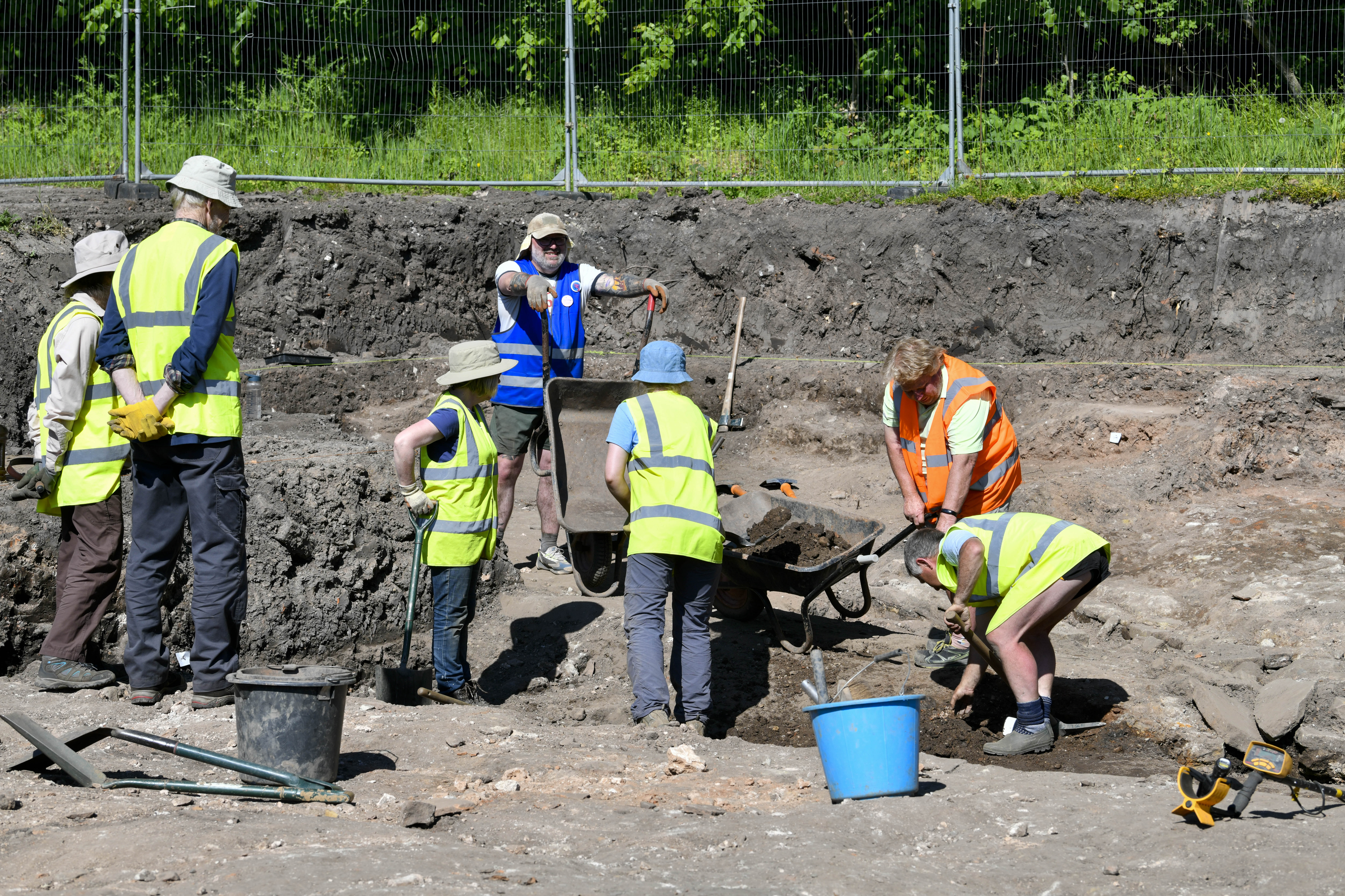 people in high vis jackets digging in soil