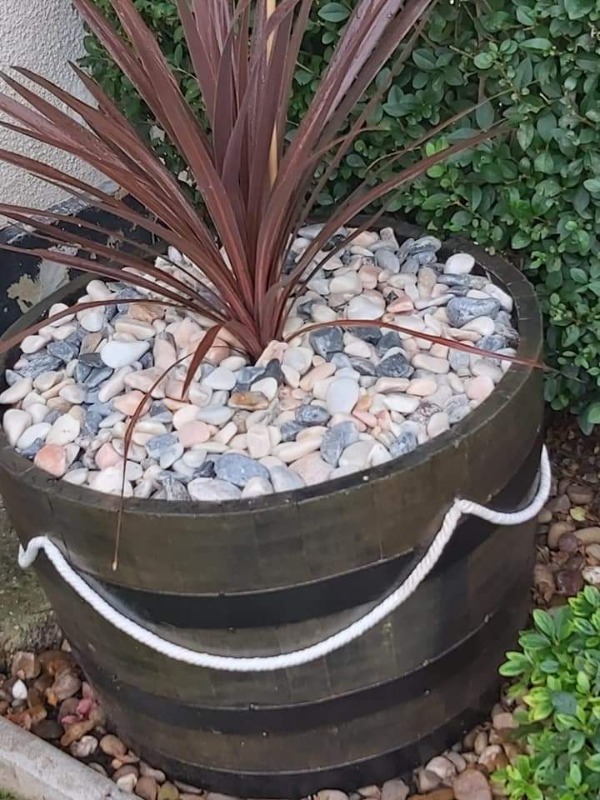 rope decorating a bourbon barrel to make a plant pot