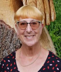 Woman with glasses and blonde hair smiling
