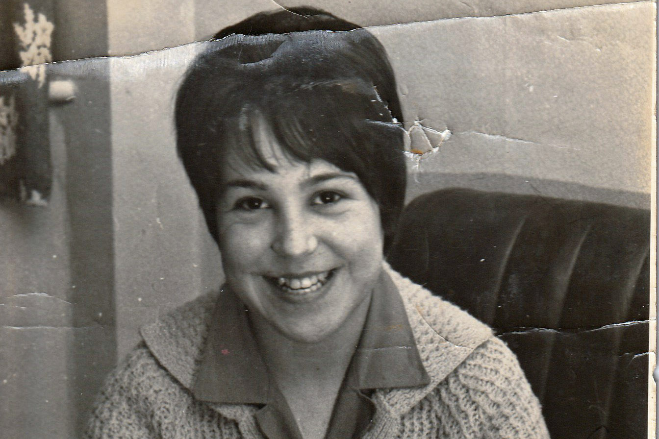 young girl with brown hair smiling at teh camera, photo is black and white