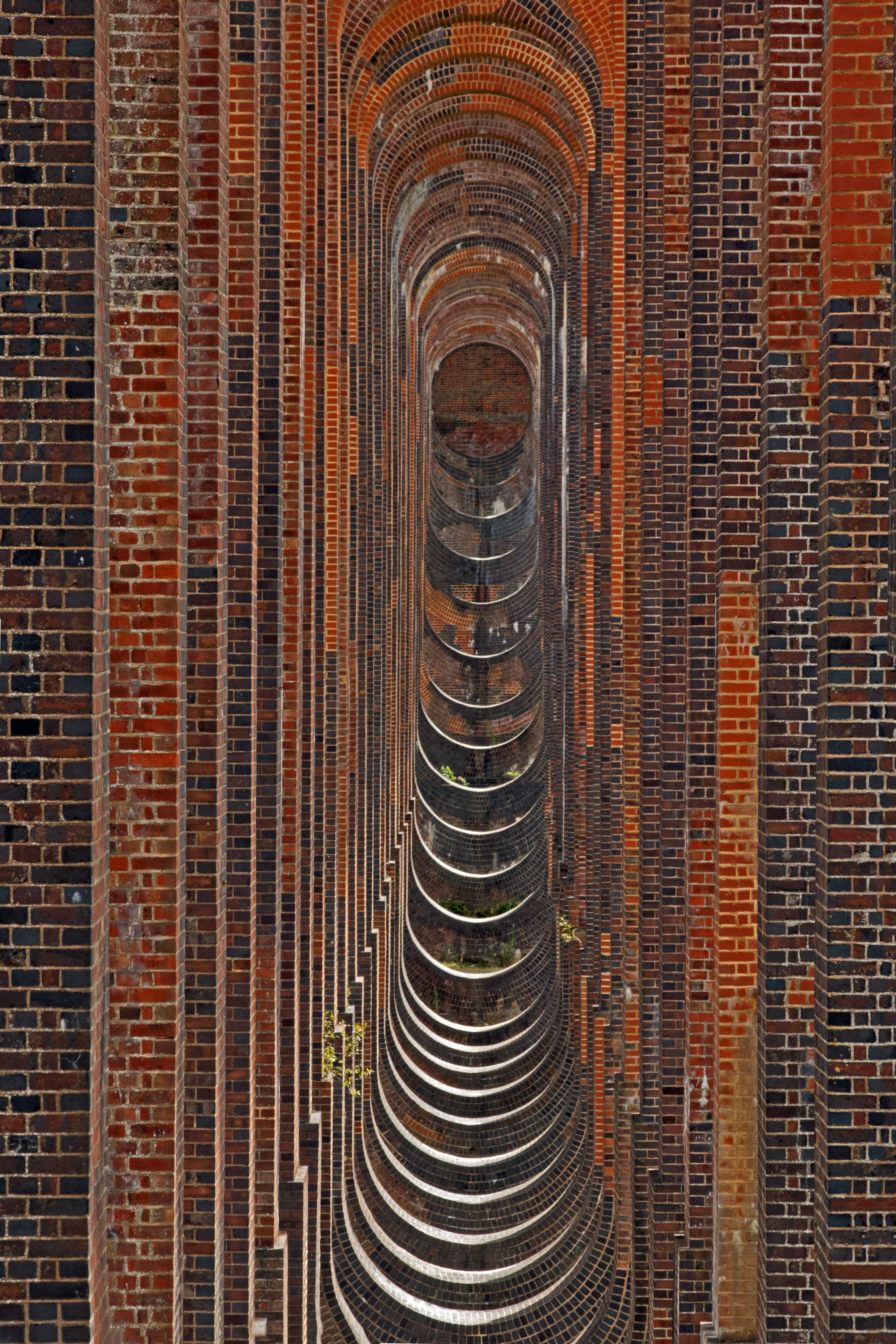 reflections in the archway of a red brick viaduct