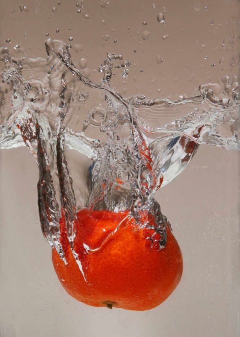 Photo of an orange being dropped into water