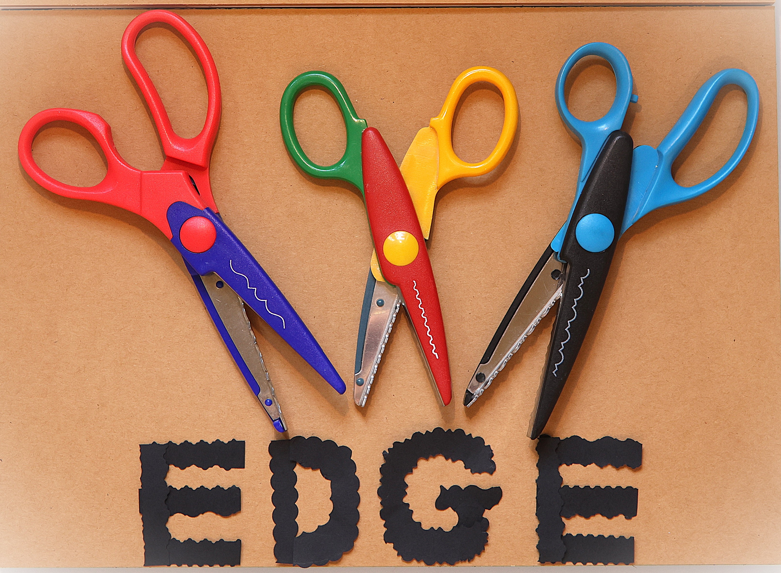 Photo of colourful scissors which have cut out the word edge