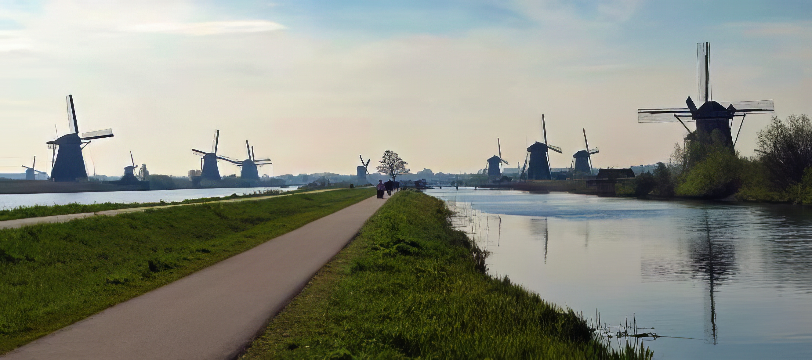 the view down a path with rivers and windmills either side of it