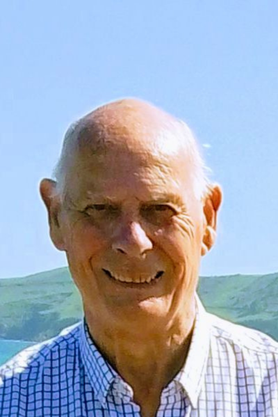 David Blanchflower, wearing a checked shirt, standing outside on a sunny day
