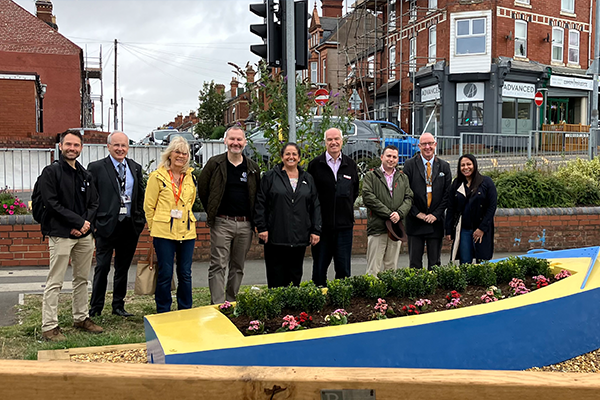 Wyre Forest u3a member Sue with representatives from Network Rail, West Midlands Trains and Worcestershire Community Rail Partnership and Community Rail Network. They are standing behind a boat that has been refurbished by u3a volunteers into a planter.
