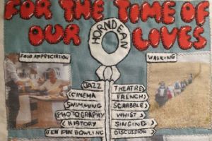 A grey quilt block with the words 'For the time of our lives' at the top. It also has a sign post with names of groups and two pictures showing a food appreciation group and a walking group.