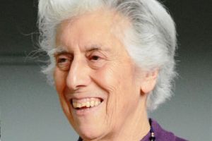 A woman in a purple top smiling