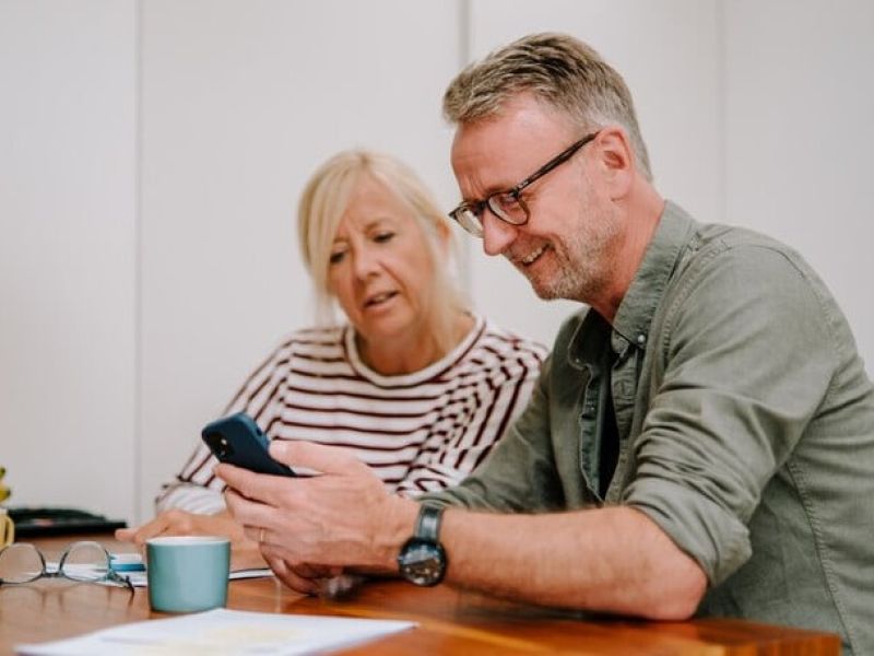 Photo of two people sharing information on a phone